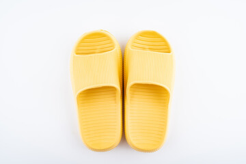 A pair of yellow slippers on white background