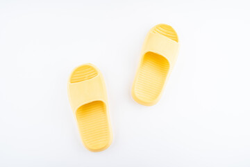 A pair of yellow slippers on white background