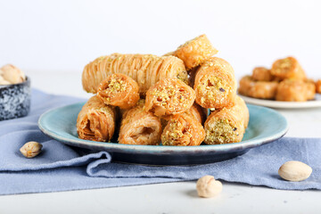 Plate with delicious baklava on light background