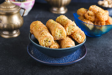 Bowl with delicious baklava on dark background