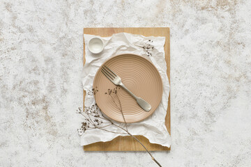 Empty plate and fork on light background