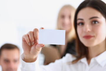 Female hand in suit give blank calling card to visitor