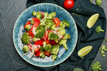 Plate of tasty salad with broccoli on dark background
