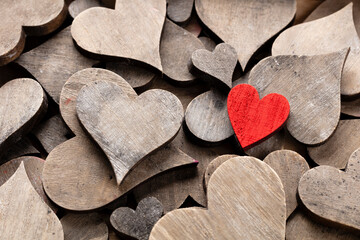 Wooden hearts, one red heart on the heart background..