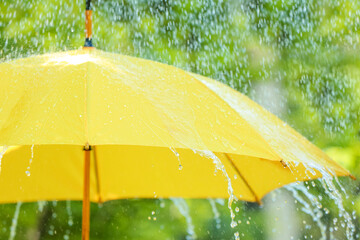Open umbrella under falling rain drops outdoors © Pixel-Shot