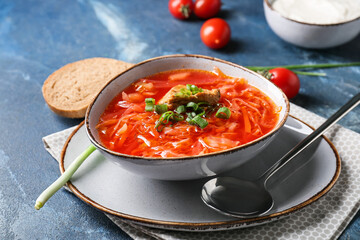 Bowl of tasty borscht on color background