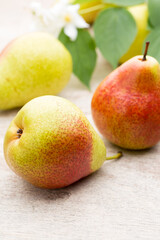 Fresh pears with leaves in a on wooden background.