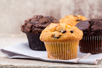 Homemade muffins with chocolate, vintage background.