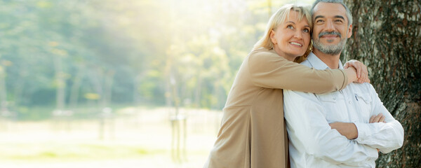 Active happy and enjoy love seniors couple embracing in autumn park