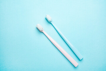 Two toothbrushes on blue background