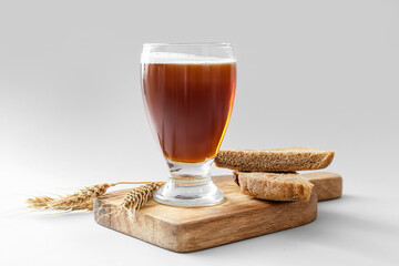 Glass of fresh kvass on light background