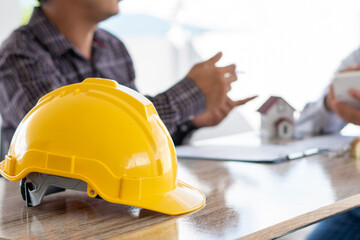 Team engineer meeting for colleagues discussing and checks construction blueprints on new project at desk in office.