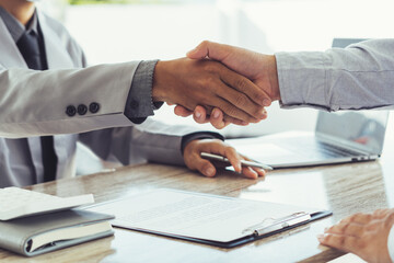 Two business people shake hands after a business deal is reached In the office area