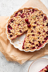 Baking dish with tasty cherry pie on light background