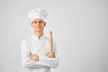 Cheerful chef in the uniform of a rolling pin in the hands of a restaurant