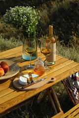 Tasty food and drink for romantic picnic on table outdoors