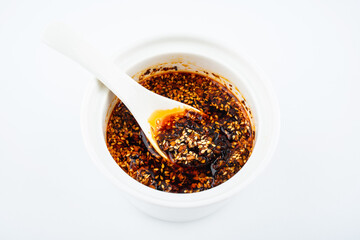 A cup of sesame oil chili on white background