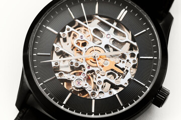 Black wrist watch with skeleton movement, close-up