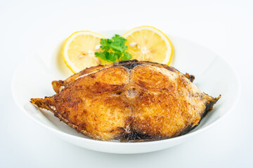 Pan-fried mackerel pieces on a plate on white background