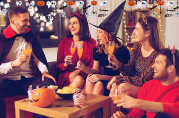 friendship, holiday and people concept - group of happy smiling friends in halloween costumes of...