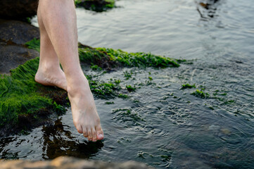 male foot touching sea water