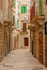 włoski flagi na balkonach na wąskiej uliczce w miejscowości Molfetta w Puglia - obrazy, fototapety, plakaty