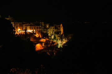 podśetloni zabytkowe kamienice na skraju urwiska widziane nocą. Tropea, Kalabria, Włochy