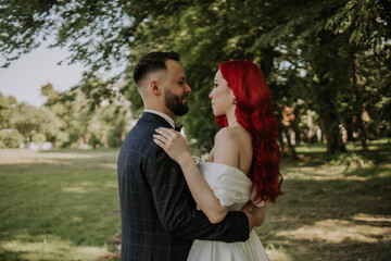 Obraz premium Wedding day. Happy bride and groom hugging and laughing Red hair diversity