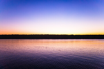 Tranquil minimalist landscape with a smooth lake surface with calm waters with a horizon and clear skies. Simple beautiful natural calm background. Copy space