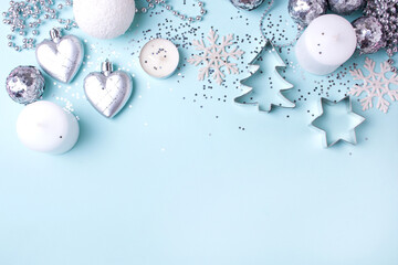 Silver and white christmas decorations on a blue background. Top of view