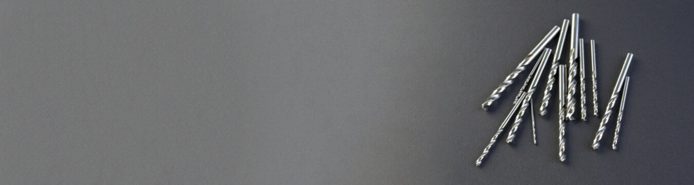 Drills for metal lie on a black paper background. Hole processing tool