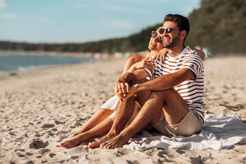 love, summer holidays and people concept - happy smiling couple chilling on beach