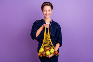 Photo of nice brunette millennial lady hold apples wear jeans overall isolated on violet color background