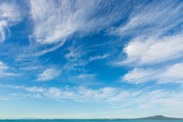 Cirrostratus cloudscape above Rangitoto on blue sky