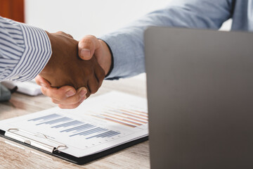 Obraz premium Two business people shake hands after a business deal is reached In the office area