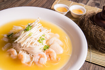 braised thin noodle with seafood prawn in yellow chicken cheese stock sauce on wood background...