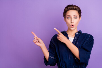Portrait of young shocked amazed girl point fingers copyspace advertise sale discount isolated on purple color background