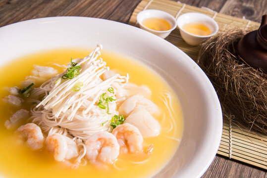 braised thin noodle with seafood prawn in yellow chicken cheese stock sauce on wood background asian halal menu