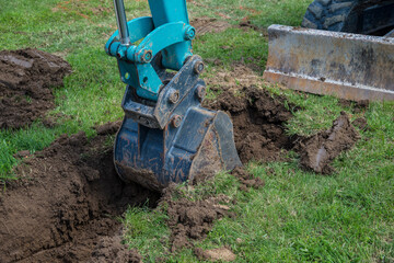 Small excavator is digging a foundation for a house