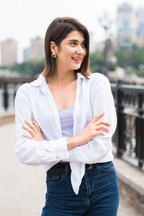Fototapeta premium Attractive, happy and stylish brunette Caucasian girl posing on the street. Lifestyle and fashion concept.