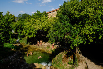 group of bathers cooling off, Molinar river, Tobera, town of the Burgos municipality of Frías, Autonomous Community of Castilla y León, Spain - obrazy, fototapety, plakaty