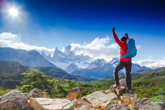 hiker celebrating success on top of a mountain in a majestic Patagonia mountain landscape. Fitz Roy, Argentina. Mountaineering sport lifestyle concept