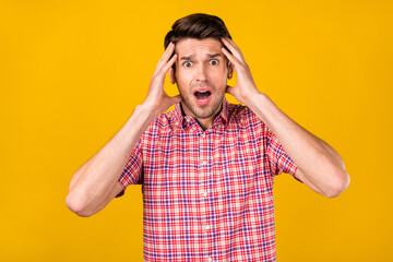 Portrait of attractive worried overwhelmed guy bad news reaction fail isolated over bright yellow...
