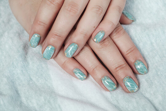 Model Woman Showing Shellac Marble Green Pastel Manicure With Gold Leaf On Short Nails