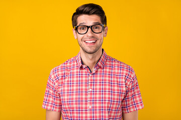 Portrait of attractive cheerful intellectual guy geek it specialist good mood isolated over vibrant yellow color background