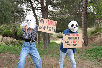 Activist protesters wearing animal masks shouting through a bullhorn.