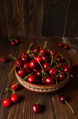 Ripe juicy cherries in a plate on a wooden background