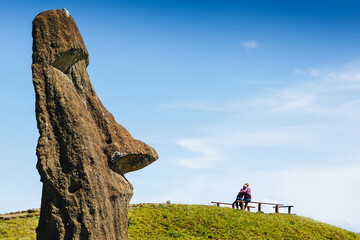 Happy couple in love and Moai statues in the Rano Raraku Volcano in Easter Island, Rapa Nui...