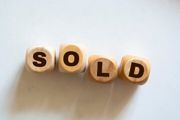 Sold word written In wooden cubes on white background. Real estate business concept