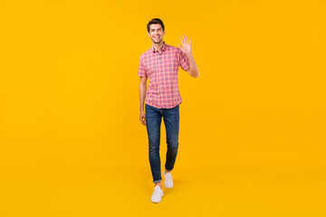 Fototapeta na wymiar Full length body size view of attractive cheerful friendly guy walking waving you isolated over bright yellow color background